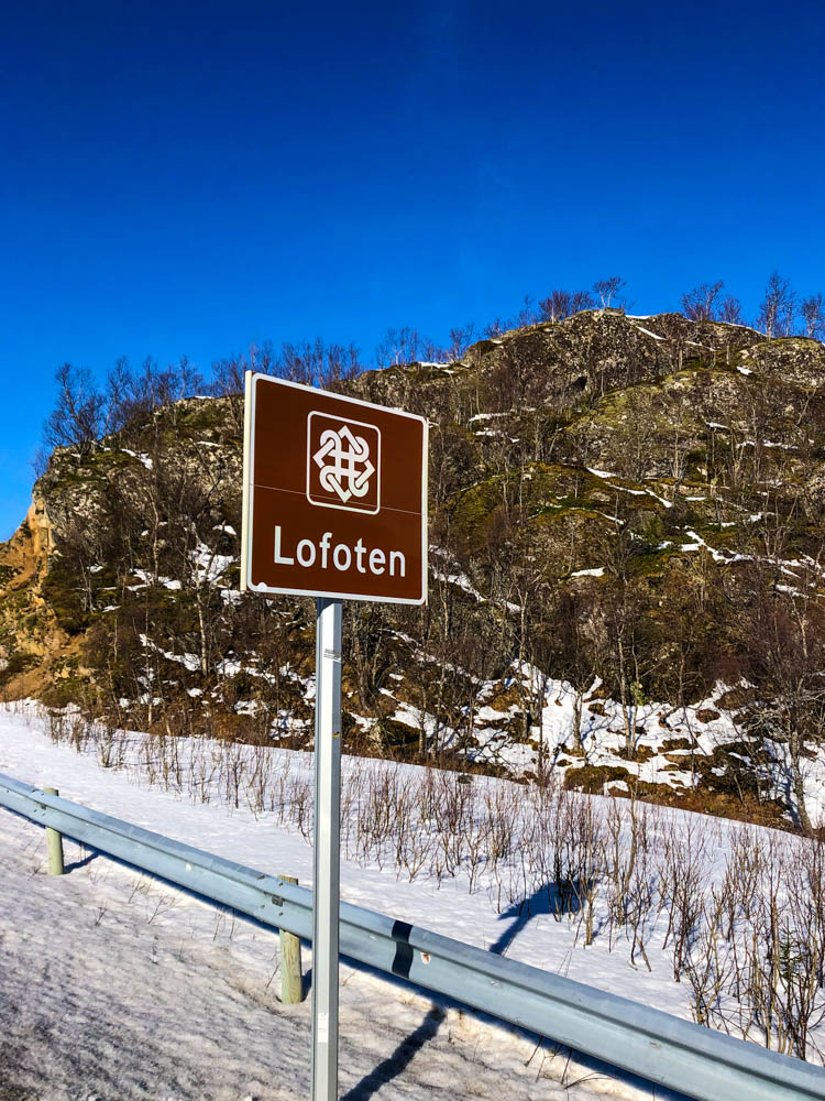 Schild "Lofoten" - Eingang der Lofoten im April - es liegt Schnee neben der Straße