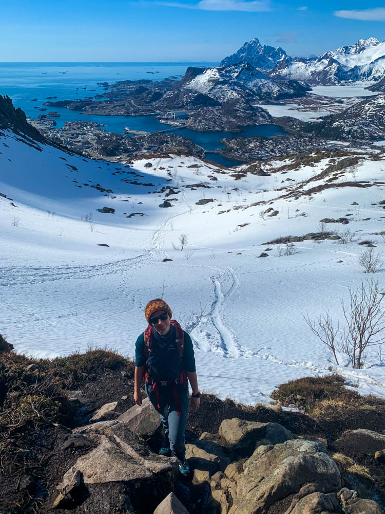 Melanie im Aufstieg zum Djevelsporten bei Svolvær. Im Tal ist Svolvær zu sehen, dazwischen liegt viel Schnee.
