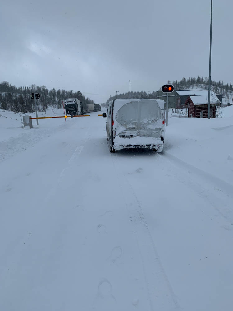 Verschneiter Pass in Norwegen. Van Vivaldi steht vor verschlossener Schranke, die Straße ist voller Schnee