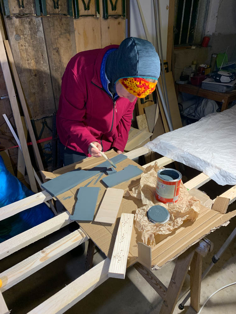 Melanie streicht die Seitenteile der Trittstufe mit Holzlack