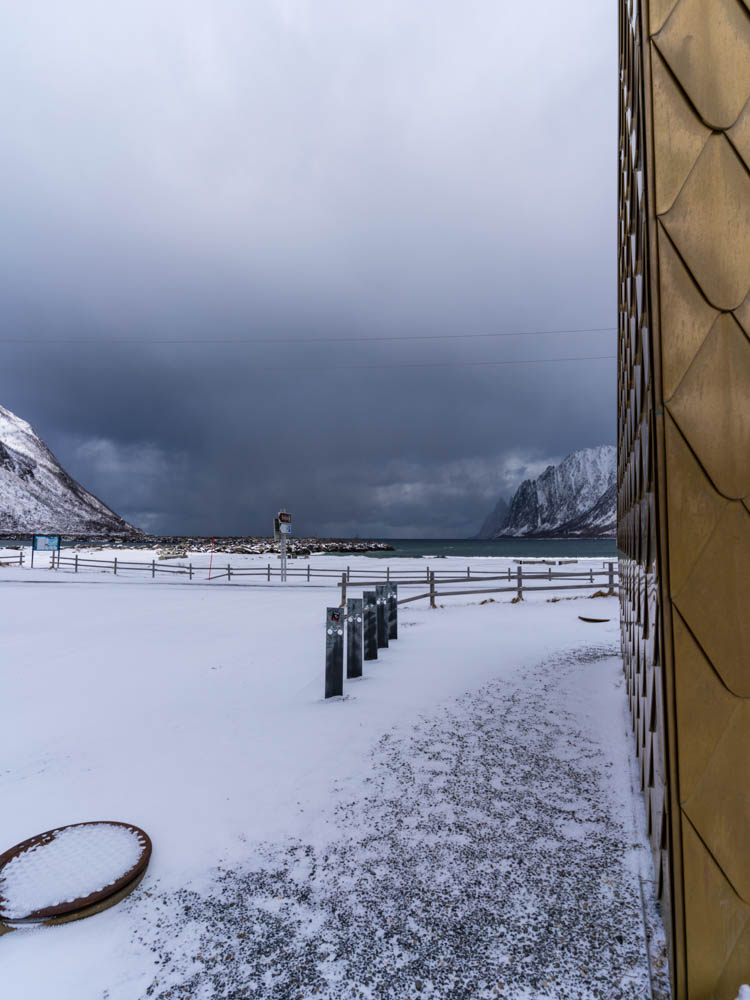 Strand und goldenes Klohaus Ersfjord. Verschneite Berglandschaft - über Senja nach Tromsö Tour Norwegen