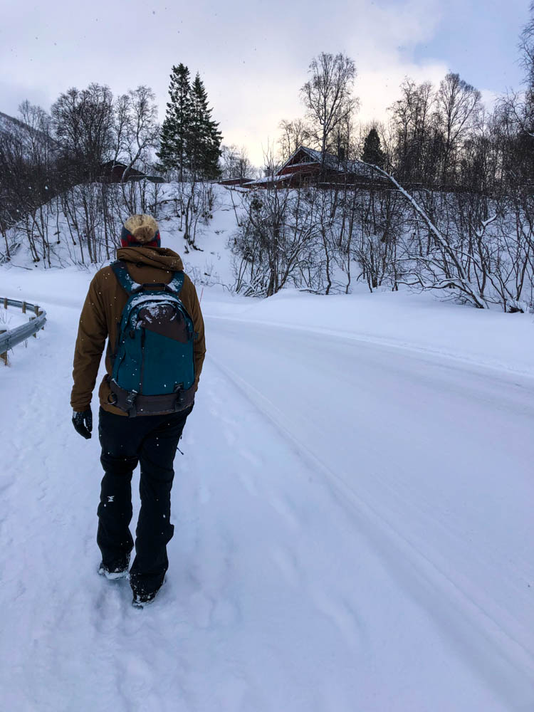 Julian läuft auf einer verschneiten Straße bei Tromsö.