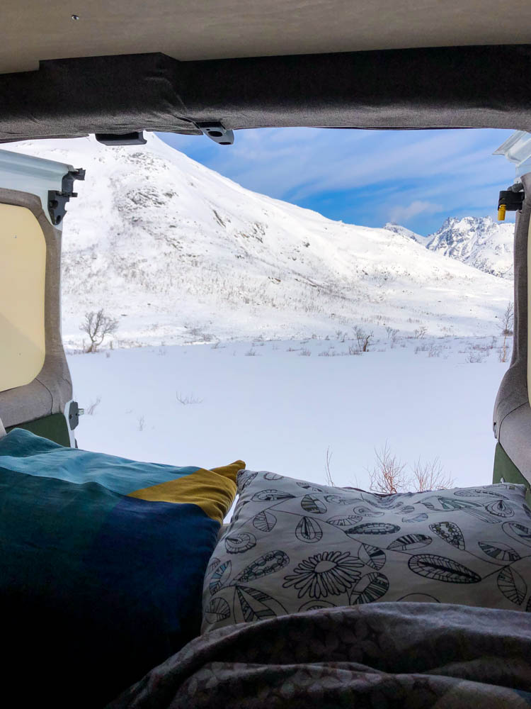 Blick aus Van Vivaldi Hecktüren - verschneite Berglandschaft Norwegens aus "Schlafzimmer" des Vans (Kissen zu sehen). Über Senja nach Tromsö - Schnee ohne Ende