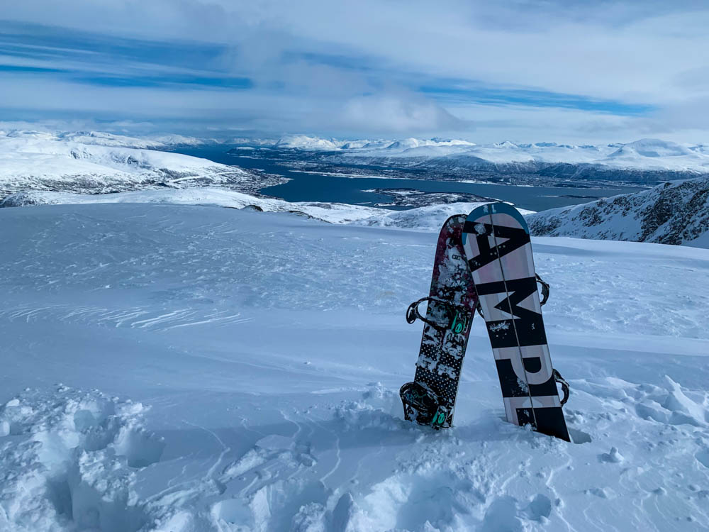 Zusammengebaute Splitboards stecken im Schnee des Gipfel Steinskarstinden. Im Hintergrund ist die verschneite Berglandschaft zu sehen. Über Senja nach Tromsö - Schnee ohne Ende