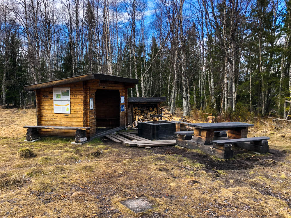 Rastplatz in einem Naturreservat in Nordschweden mit Hütte, Feuerstelle sowie Bänken und einem Tisch