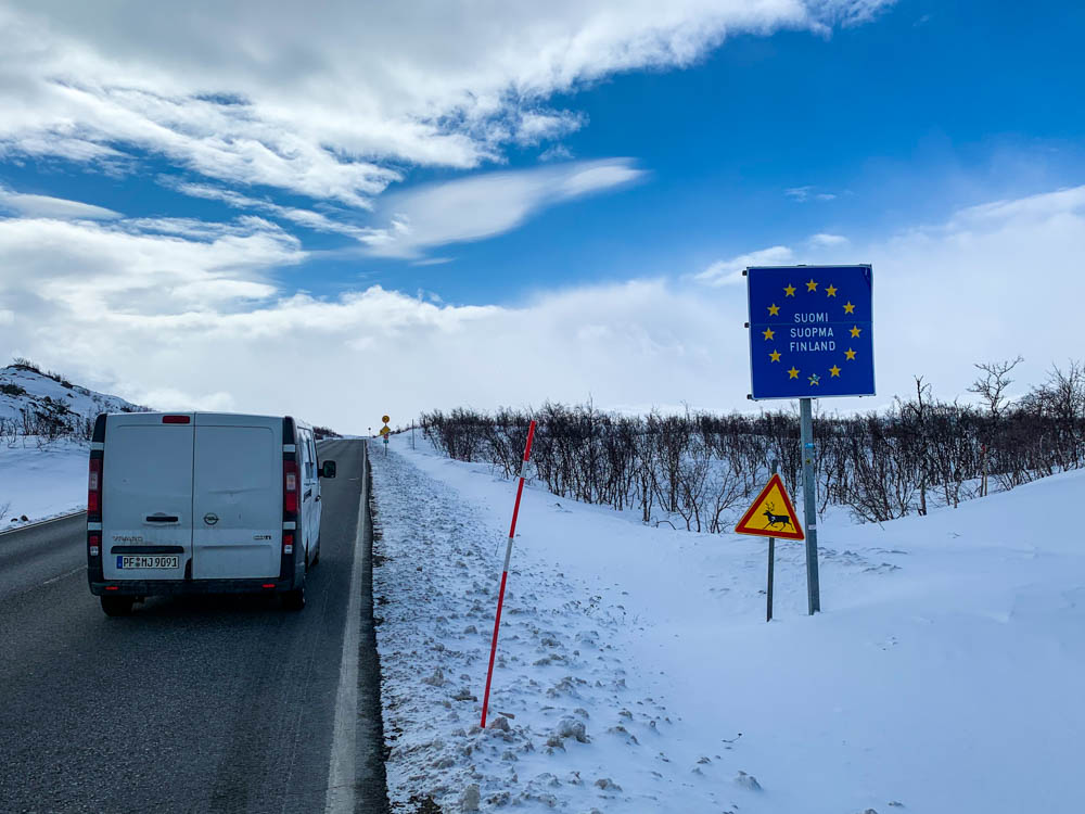 Van Vivaldi fährt über die Grenze von Norwegen nach Finnland. Es liegt überall Schnee, der Himmel ist teilweise bewölkt.