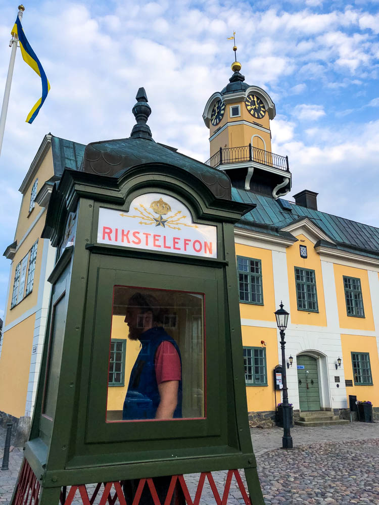 Söderköping Altstadt. Julian ist in einer alten Telefonzelle und probiert das Gerät aus.