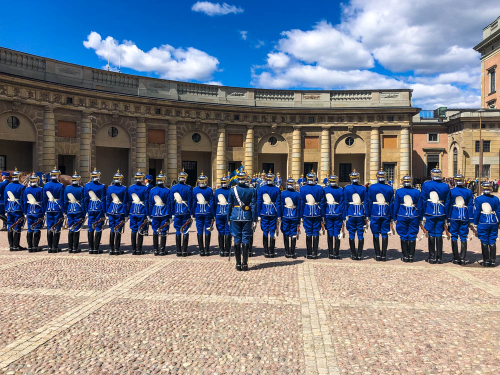 Wachwechsel im Hof des Königspalastes in Stockholm. Die Wachleute stehen in einer Reihe, gegenüber sind die bisherigen Wachleute, welche gewechselt werden.