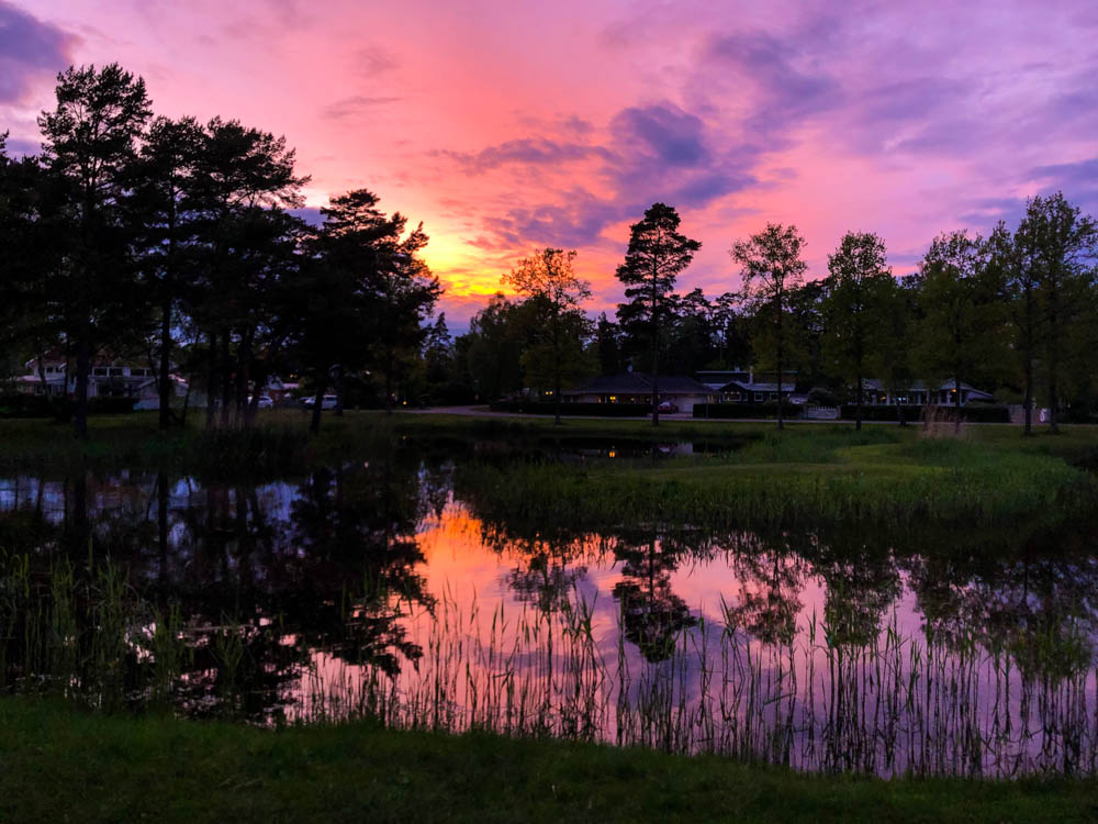 Sonnenuntergang bei Kalmar. Der lila-pinke Himmel spiegelt sich in einem See. Sonnenuntergang Südschweden