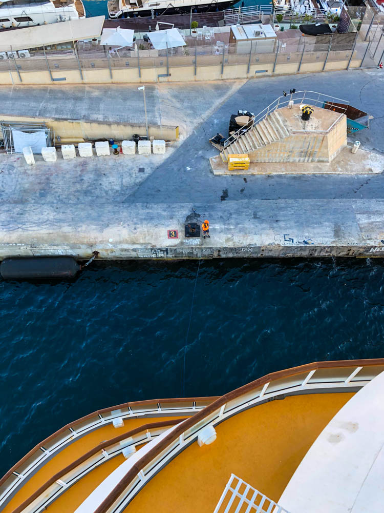 Die AIDAblu beim Anlegen im Hafen von Valetta. Die Aufnahme ist von einem der oberen Decks gemacht. Man sieht noch ein paar Decks unterhalb und den gesamten Hafenanleger in diesem Bereich.