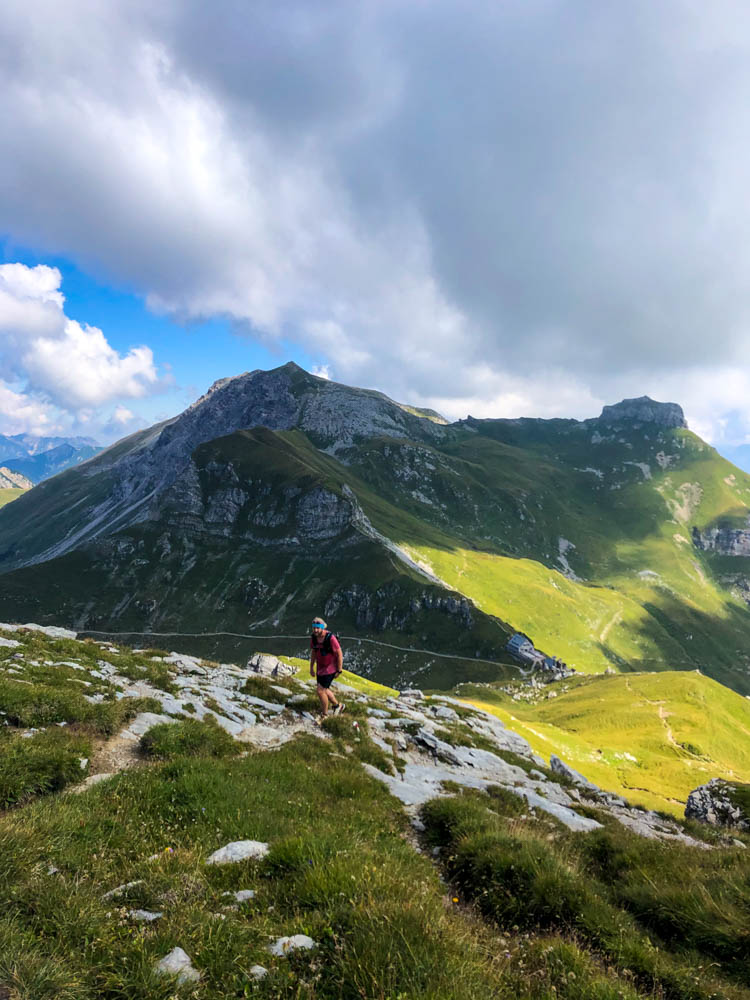Wanderungen in Liechtenstein. Julian im Aufstieg zum Augstenberg auf dem Fürstin Gina Weg. Es sind ein schönes Bergmassiv sowie ein paar dunkle Wolken zu sehen