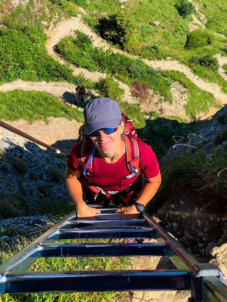 Touren im Allgäu - Melanie auf einer 17 Meter langen Leiter, welche zum Steineberg führt. Sie grinst in die Kamera. Wandern in der Nagelfluhkette.