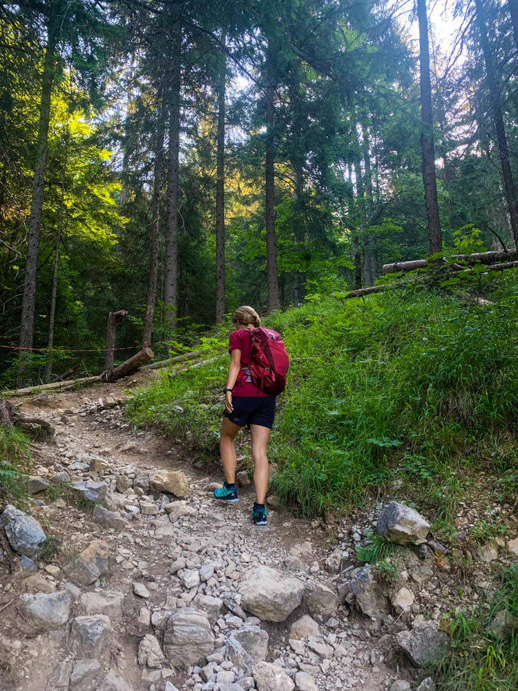 Touren im Allgäu - Melanie im Aufstieg zum Schrecksee in den Allgäuer Alpen. Es geht über einen steilen Schotterweg in einem Waldstück nach oben