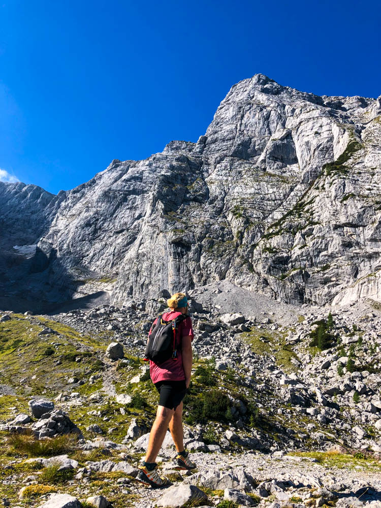 Julian auf dem Weg zur Schärtenspitze in den Berchtesgadener Alpen. Der Himmel ist kräftig blau und das Felsmassiv sieht toll aus.