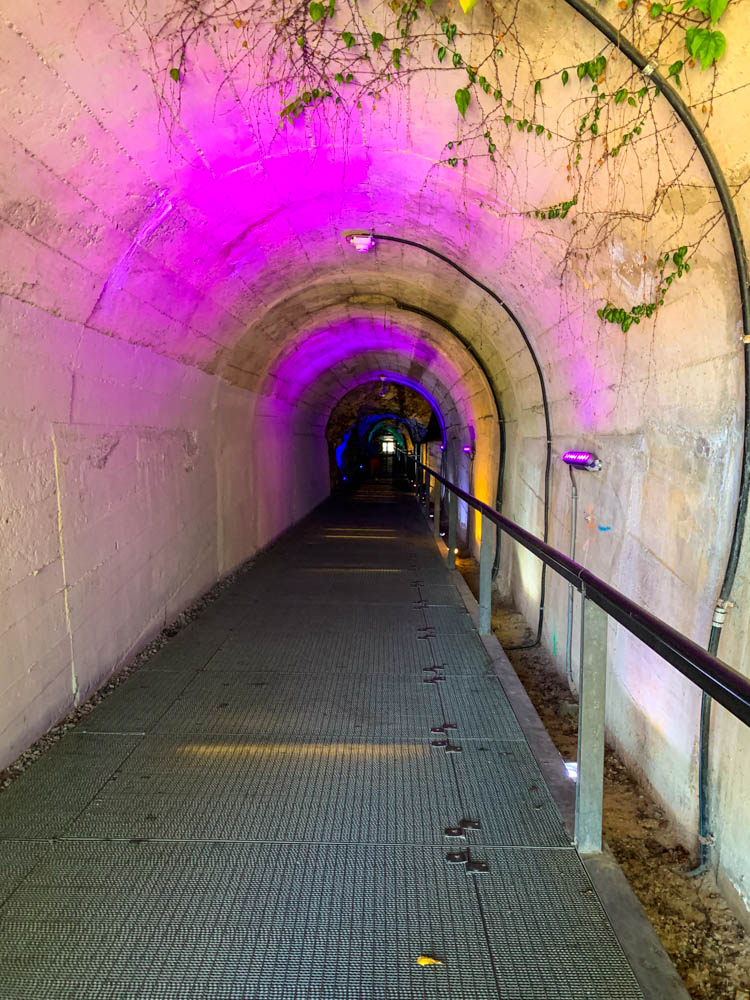 Tunnel, welcher pink beleuchtet ist, in Graz. Dieser führt unter dem Schlossberg hindurch.