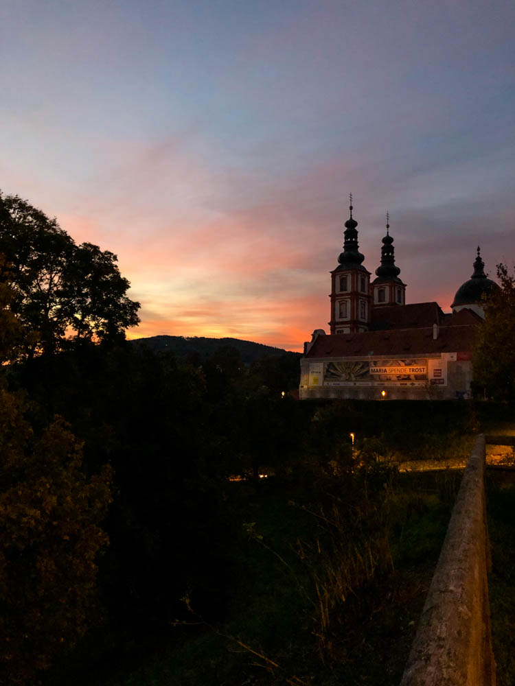 Sonnenuntergang bei Basilika Maria Trost bei Graz. Querfeldein durch Österreich bis nach Graz. Der Himmel ist orange rot verfärbt