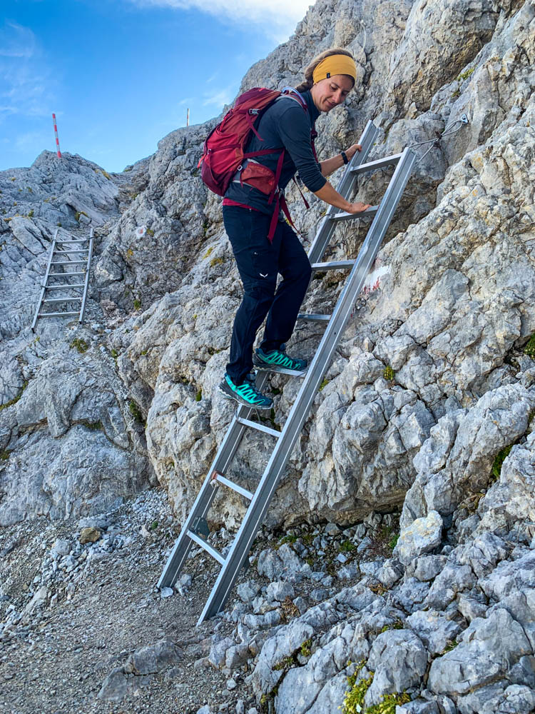 Melanie klettert eine Eisenleiter hinab. Wanderung zum Hochkönig in den Berchtesgadener Alpen