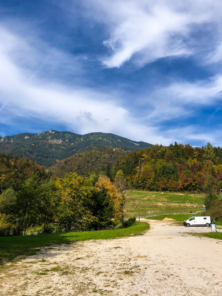 Van Vivaldi in den Bergen Sloweniens. Es ist viel Natur in dem Bild zu sehen, der Van ist nur klein rechts am Rand zu sehen. Der Himmel ist leicht bewölkt