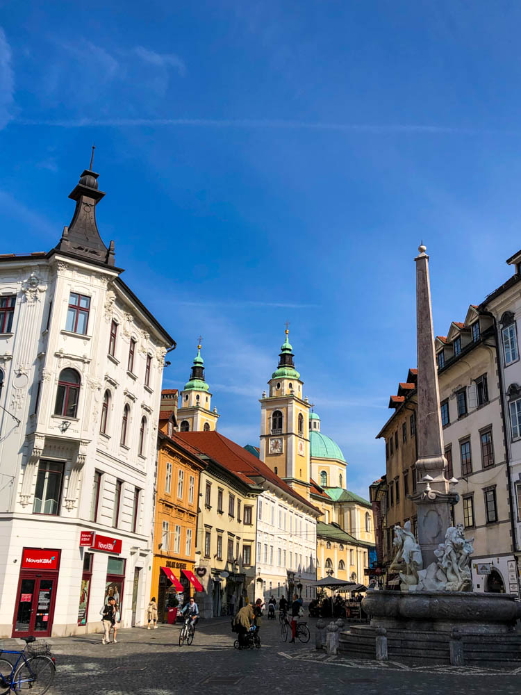 Ein Platz in Ljubljana mit einem Brunnen, einer Kirche sowie schönen Fachwerkhäuser. Hauptstadt Slowenien Roadtrip