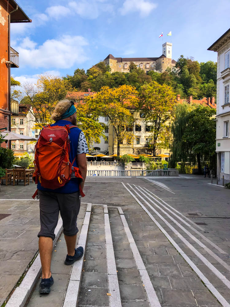 Julian läuft durch Ljubljana, der Hauptstadt Sloweniens. Vor ihm ist eine Burg zu sehen.