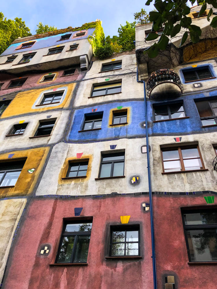 Hundertwasserhaus in Wien. Das Gebäude ist etwas verwinkelt und die Fassade ist bunt bemalt. Querfeldein durch Österreich in die Hauptstadt