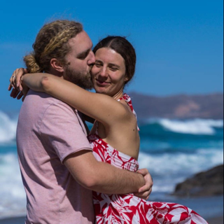 links für patrablo - Avatar von Melanie und Julian - Julian gibt Melanie einen Kuss auf die Backe. Sie stehen am Strand in Fuerteventura