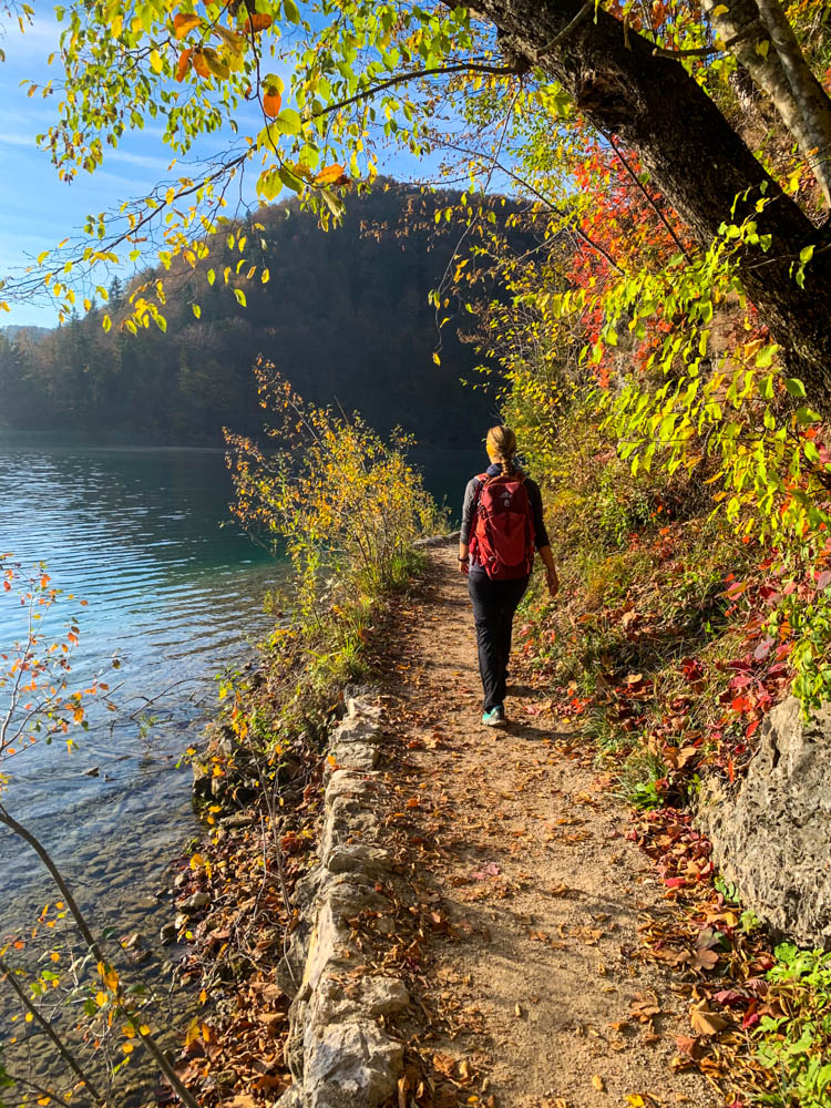 Melanie spaziert entlang eines Sees im Nationalpark Plitvicer Seen in Kroatien. Herbstliche Farben