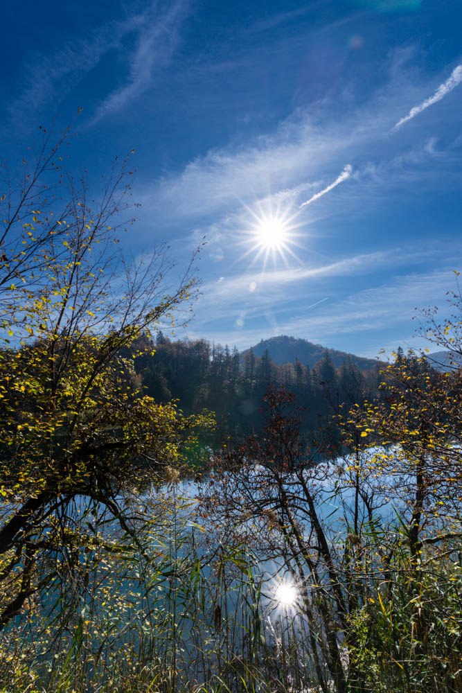 Sonnenstern am Himmel sowie als Spiegelung im See im Nationalpark Plitvicer Seen in Kroatien. Herbst in Kroatien.
