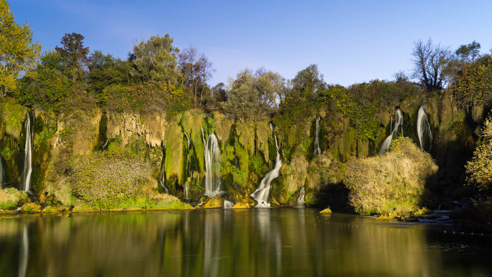 Kravica-Wasserfälle in Bosnien und Herzegowina. Es ist viel grüne Natur zu sehen mit einigen Wasserfällen, die zwischen den Flechten und dem Moos fließen.