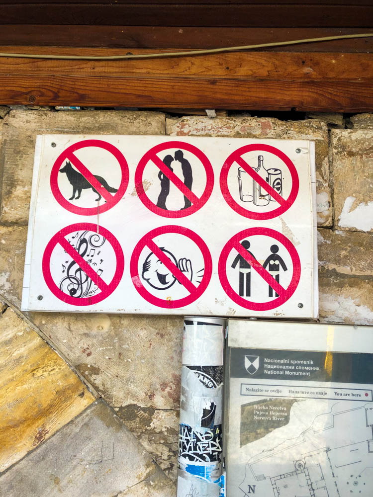 Schild vor einer Moschee in Mostar (BIH) mit durchgestrichenen Symbolen wie z.B. Musik und Hunde verboten.