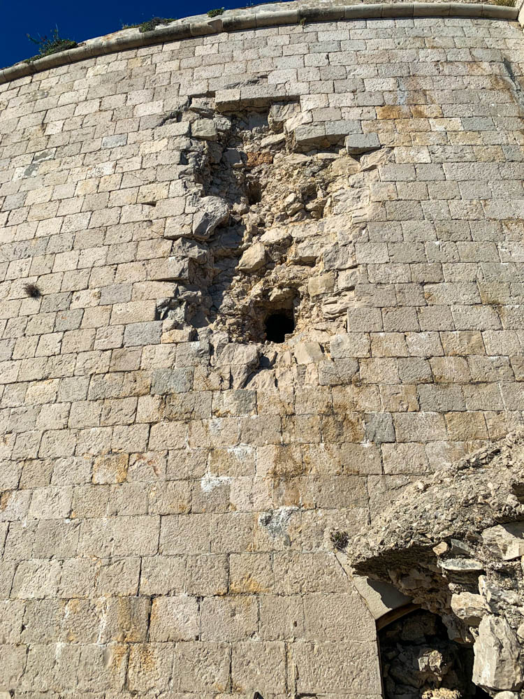 Lost Place in Kroatien. Alte Burganlage, in wessen Mauer große Einschusslöcher von Kanonen zu sehen sind.