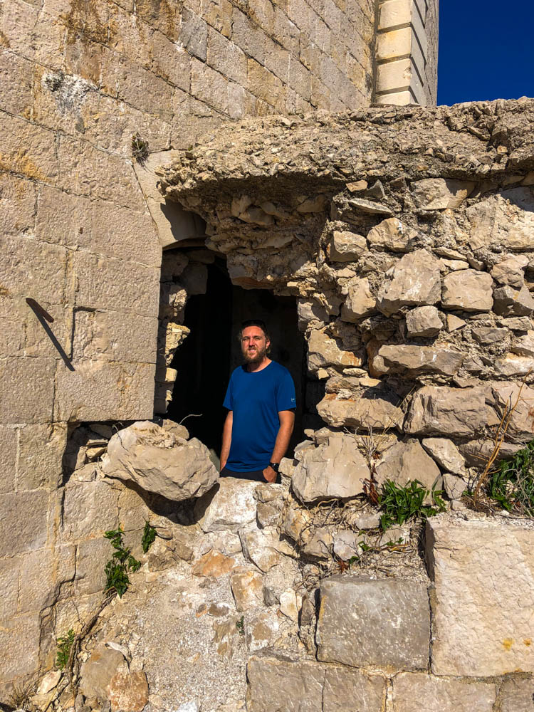 Julian steht in einer alten, verlassenen Burganlage im Süden Kroatiens. Lost Place