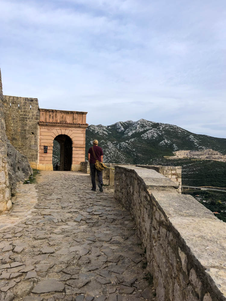 Julian läuft auf einer Burgmauer bei Split