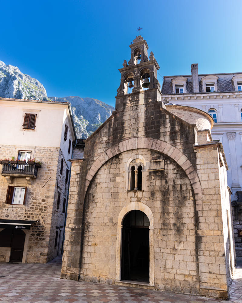 Kirche in Kotor und ein paar weitere Häuser. Der Himmel ist kräftig blau. Roadtrip Montenegro