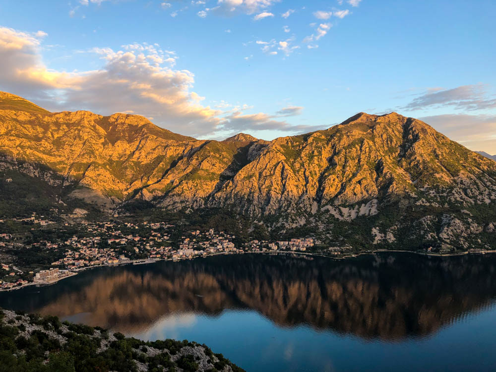 Letzte Sonnenstrahlen in der Kotor Bucht. Die Hügel spiegeln sich im glatt gezogenen Wasser. Roadtrip Montenegro