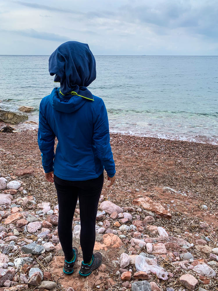Melanie nach einer Freiluftdusche am Meer. Sie hat ein Handtuch auf dem Kopf und blickt auf das Mittelmeer Montenegros.
