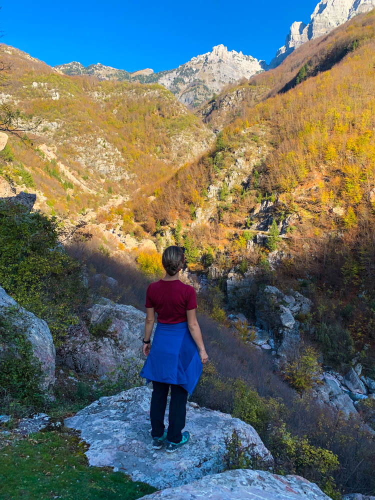 Melanie blickt auf die vor ihr liegende Berglandschaft in Theth Albanien.
