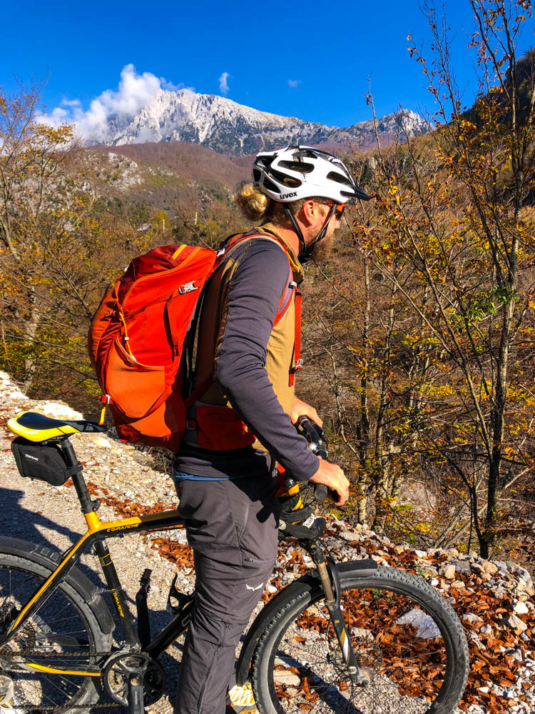 Julian blickt auf die albanische Gebirgslandschaft. Er macht gerade eine Pause beim Fahrradfahren.