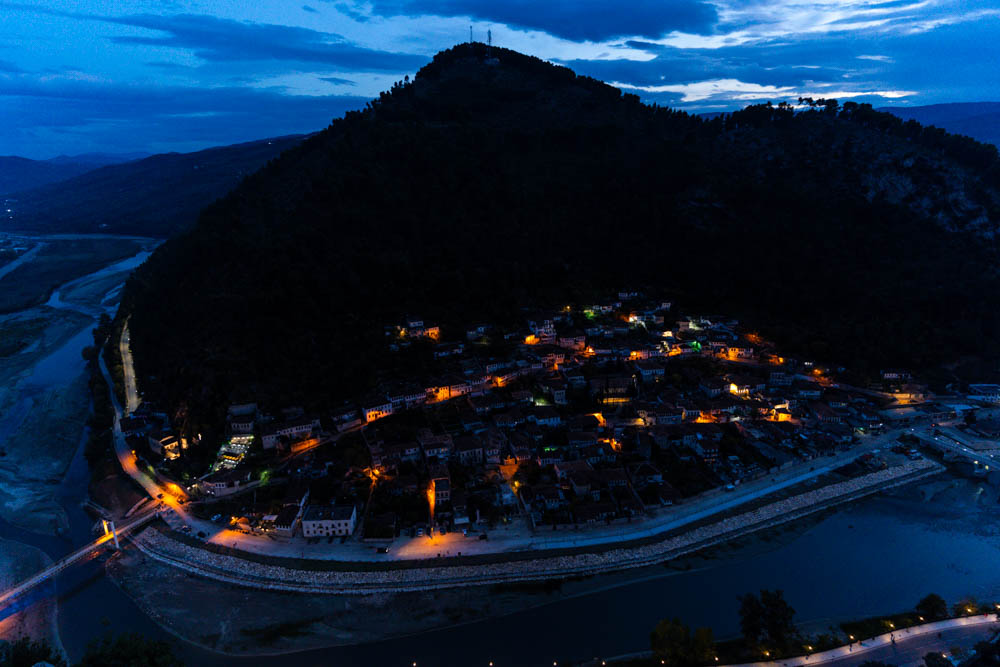 Berat, die Stadt der tausend Fenster, bei Nacht. Es leuchten ein paar Lichter in der Stadt. Aufnahme von der Burg, welche über Berat (Albanien) thront.