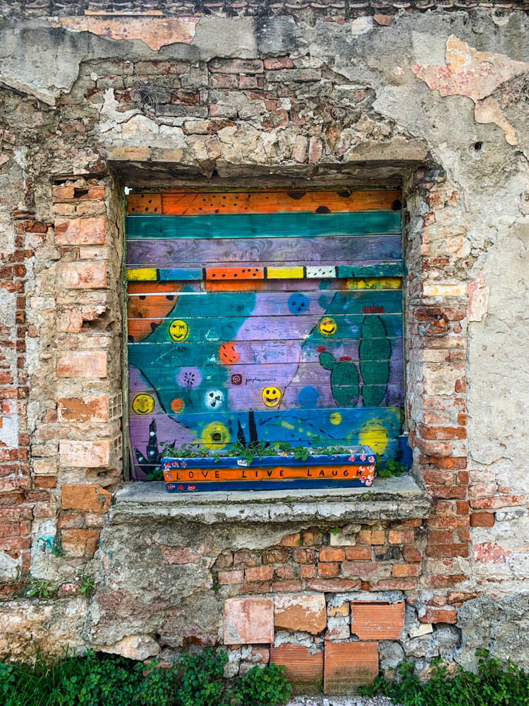 Streetart in Shkodra Albanien in einem Art Fenster in einer Mauer.