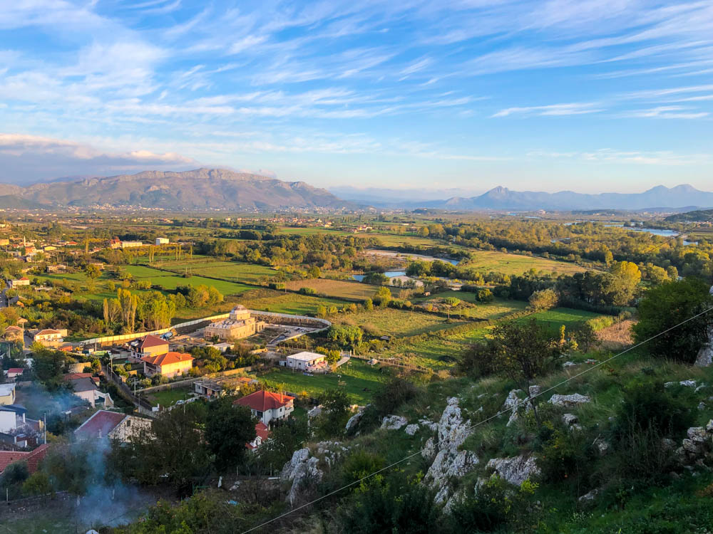 Ausblick von Burg Rozafa in Shkodra auf Landesinnere. Grüne Felder, ein paar Häuser und bergige Landschaft. Albanien - ein Land voller Gegensätze