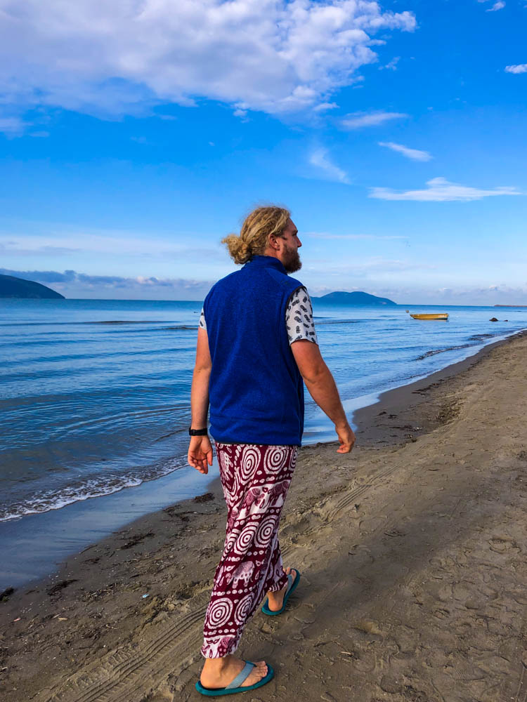 Julian geht am Strand bei Vlora Südalbanien spazieren. Das Meer hat eine tolle blaue Farbe und harmoniert schön mit dem blauen Himmel.
