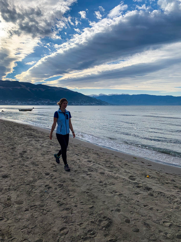 Melanie läuft am Strand spazieren bei Vlora Südalbanien. Die Wolken werden von der Sonne beleuchtet und ergeben ein schönes Bild.