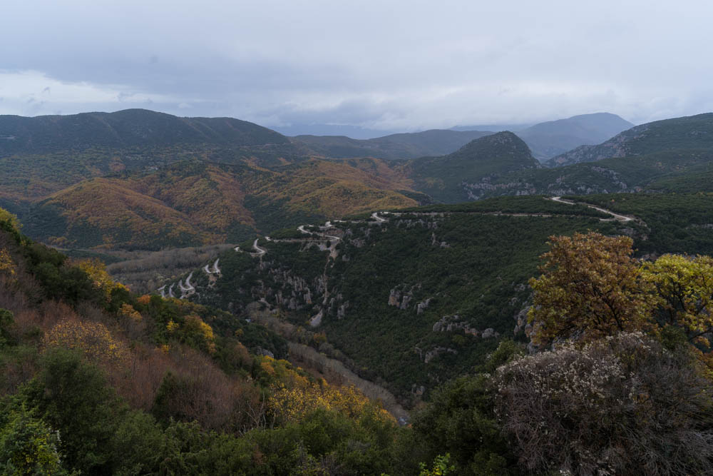 Pindos Gebirge in Griechenland. Mitten in der Wald-Landschaft ist eine Serpentinenstraße zu sehen.