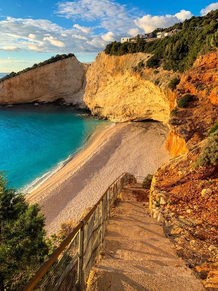 Paradiesische Strandbucht auf Lefkada in Griechenland. Es führt eine Treppe zum Strrand. Das Wasser ist türkisfarben. Zur Ruhe kommen auf einer griechischen Insel