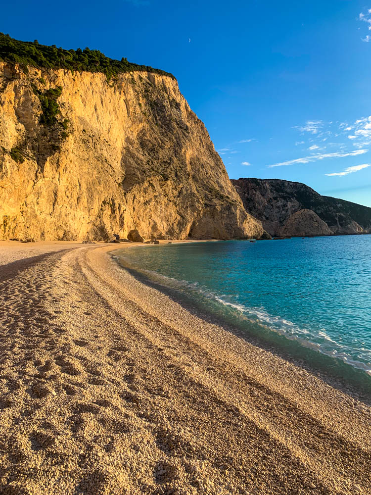 Paradiesische Strandbucht auf Lefkada in Griechenland, perfekt um zur Ruhe zu kommen. Das Wasser ist türkisfarben und der Himmel kräftig blau. Die Abendsonne beleuchtet die Felsformation, welche auf dem Bild zu sehen ist.