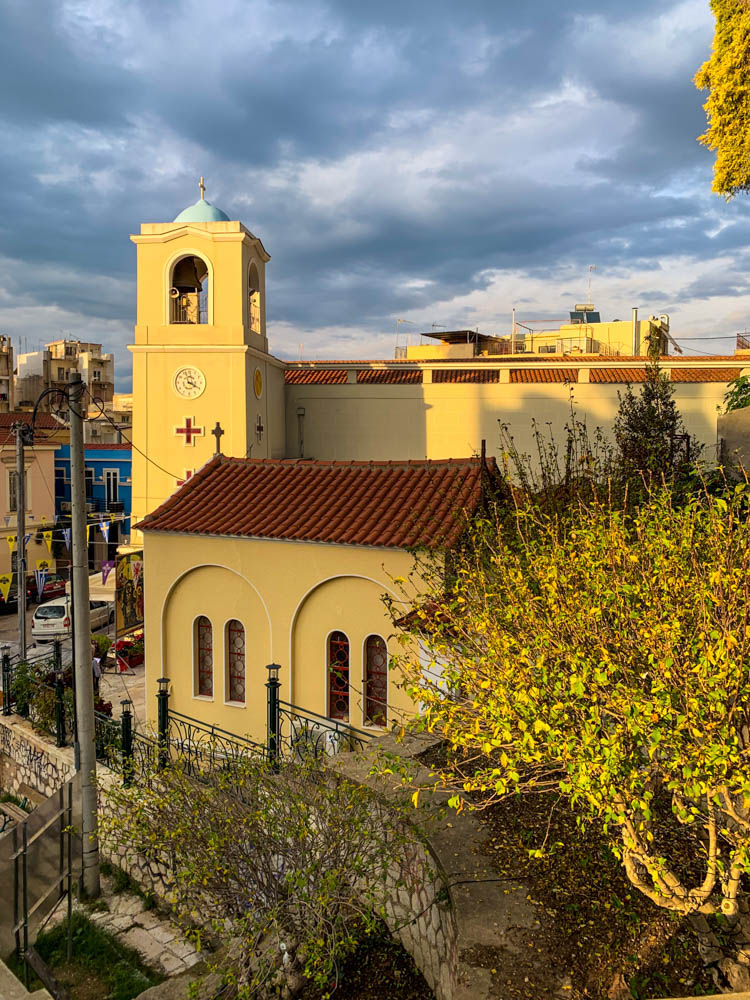 Kirche in Patras, welche von der Sonne angeschienen wird. Der Himmel ist bewölkt