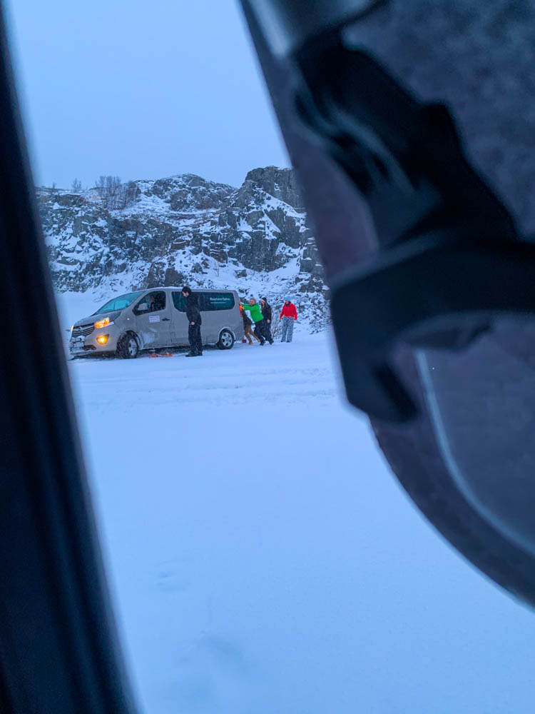 Straßenverhältnisse im Winter in Skandinavien. Aufnahme aus einem Fenster in Van Vivaldi. Julian hilft einer Gruppe von Menschen, die mit ihrem gemieteten Auto im Straßenrand liegen. Sie sind zu weit nach rechts gekommen und dann im Schnee versunken.