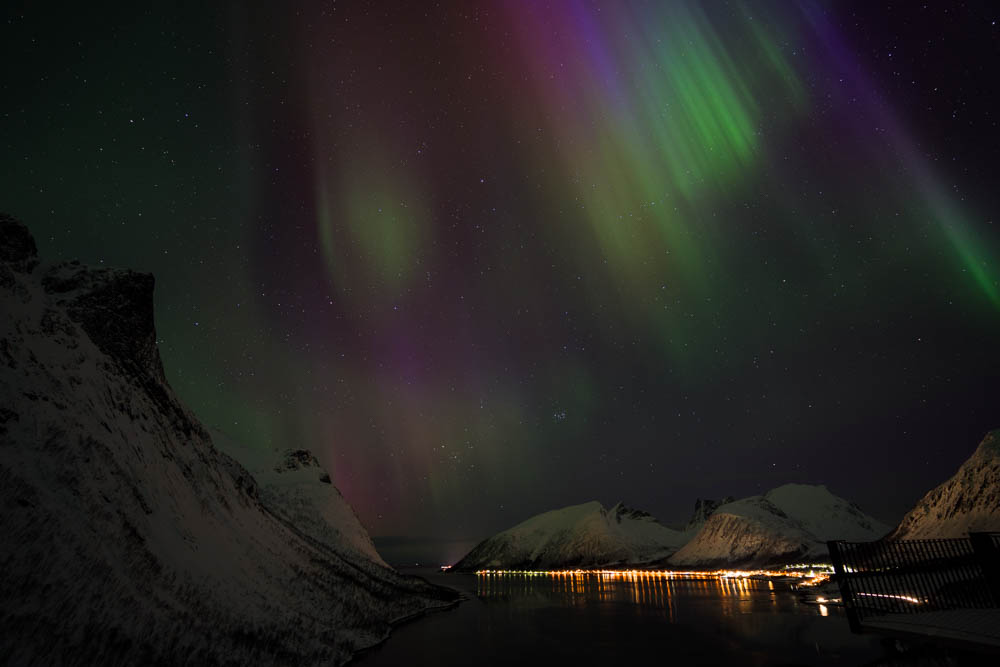 Nordlichter auf Senja (Norwegen) fotografiert. Es tanzen blaue, grüne sowie violette Lichter am Himmel, welcher voller Sterne ist. Blick auf Fjord - Skandinavien im Winter.