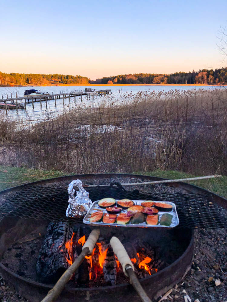 Grillen in einem Naturreservat in Schweden. Die Sonne ist gerade am untergehen, schöne Dämmerstimmung an einem See.